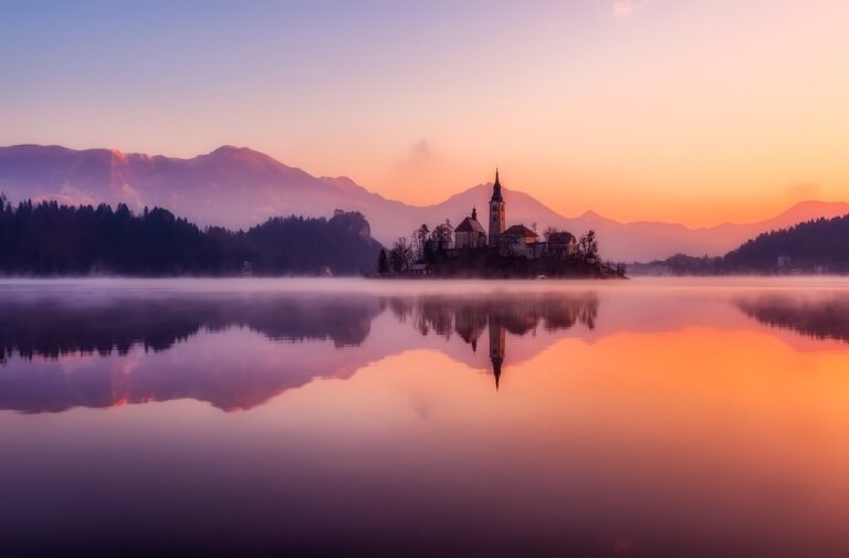 Horské jezero obklopené horami za slunečného dne