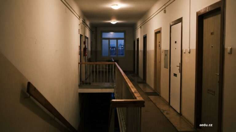 Chodba bytového domu se zavřenými dveřmi a schodištěm