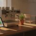 Tablet s barevnou týdenní mřížkou směn na pultu kavárny vedle kávovaru před otevřením