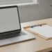 Notebook a psací podložka s papírem na stole malé kanceláře