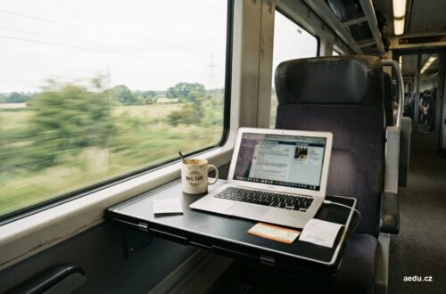 Notebook, jízdenka a účtenky na stolku ve vlaku
